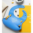 Rose pink silicone bib with printed prayer text, surrounded by fish-shaped snacks and blueberries on a yellow background.