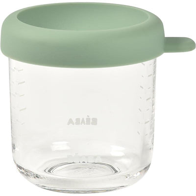 Beaba 8 oz glass baby food jar in sage color with a silicone lid, featuring measurement markings on the side.