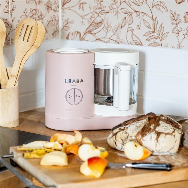 Beaba Babycook Neo Baby Food Maker in cotton candy color, designed for steaming and blending baby food, displayed with sliced fruits.