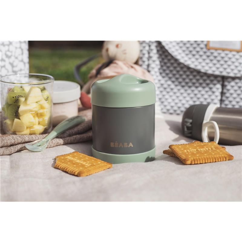 Stainless steel insulated food jar by Beaba in sage color, surrounded by snacks and fruit.