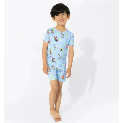 A smiling child in a light blue short-sleeve pajama set featuring colorful Spongebob Squarepants characters.