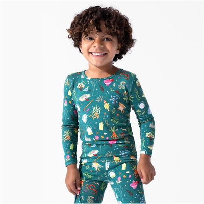 Bamboo kids pajamas featuring colorful Harry Potter-themed mandrakes and herbs, worn by a smiling child.