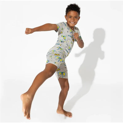 Toddler boy wearing a gray Batman-themed bamboo short set, striking a playful pose with a big smile.