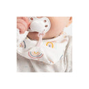 Baby wearing a pink rainbow-patterned bandana pacifier holder while holding a pacifier.