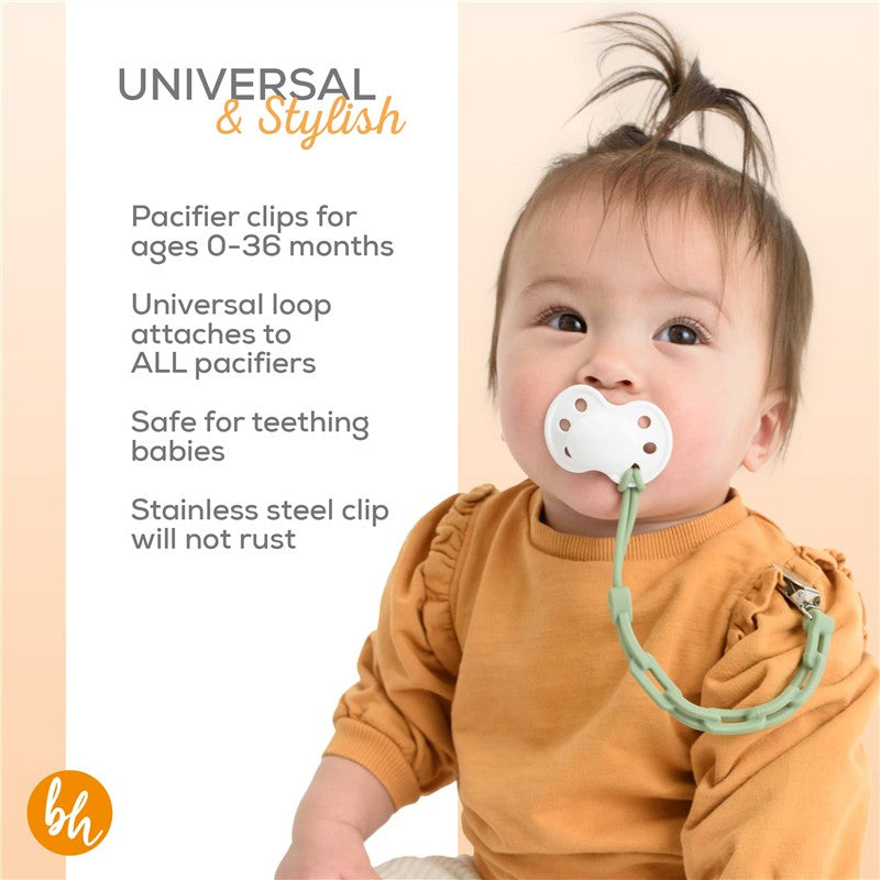Sage green BooginHead pacifier clip securely attaches a white pacifier to a baby wearing a rust-colored shirt, promoting safety and style.