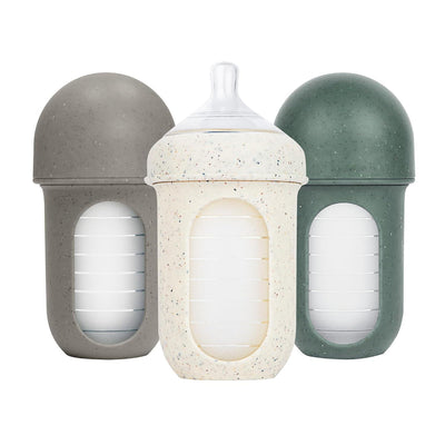 Boon 8 Oz Nursh silicone baby bottles in speckle green, gray, and speckled white with transparent measurement markings.