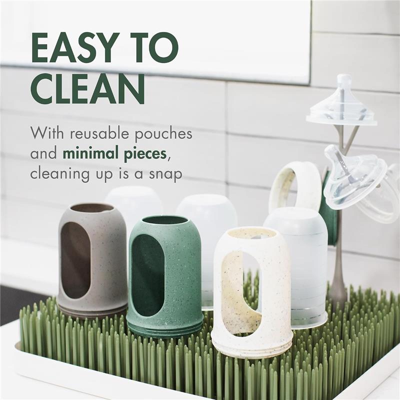 Boon 8 Oz Nursh silicone baby bottles in speckle green and various colors, displayed on a drying rack with reusable pouches.