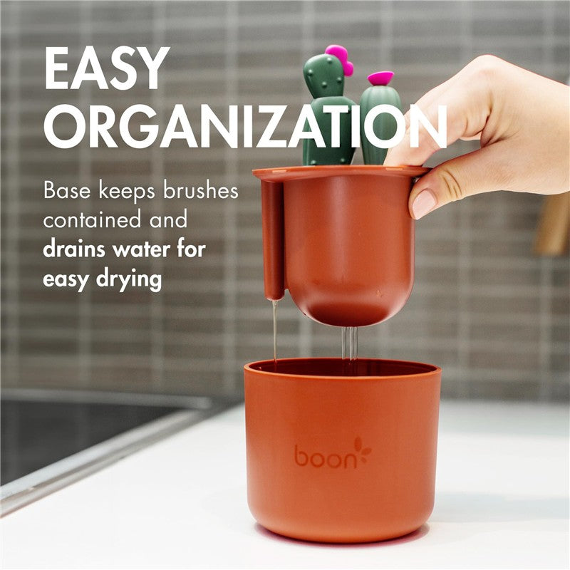 Boon Cacti Bottle Cleaning Brush Set with a brown base for drying, featuring cactus-shaped brushes and water drainage.