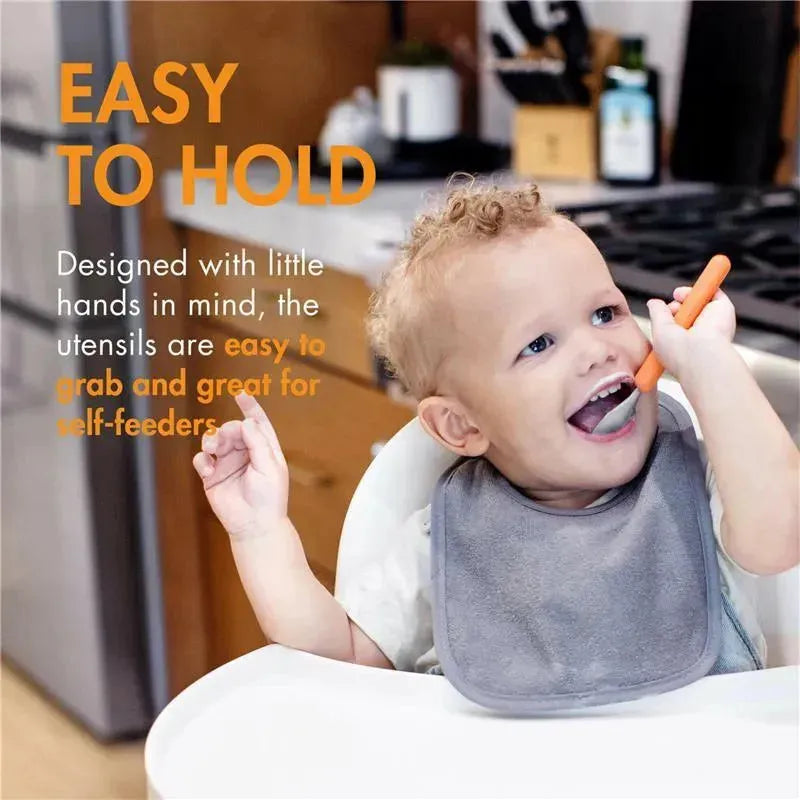Toddler using a mint-colored fork and spoon set, smiling while eating, with a focus on easy-to-hold utensils.