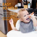 Toddler using a mint-colored fork and spoon set, smiling while eating, with a focus on easy-to-hold utensils.