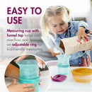 Toddler uses a measuring cup with funnel top and adjustable ring for easy pouring while a bag of ingredients is in hand.