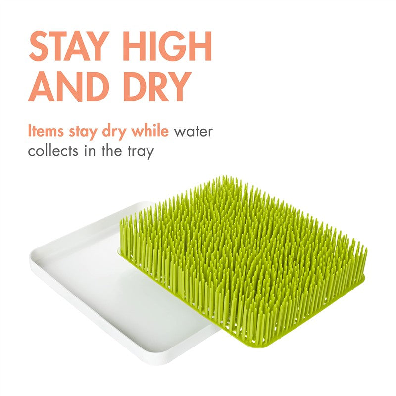 Boon LAWN drying rack with a green grass-like surface and white tray; designed to keep items dry while collecting water.