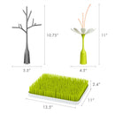Boon LAWN drying rack features a green grass base, a gray tree, and a white flower with orange accents for drying baby bottles and accessories.