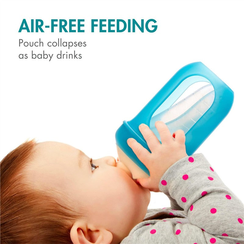 Boon NURSH silicone pouch bottle in blue, 4 oz, held by a baby for air-free feeding, with collapsible pouch feature.