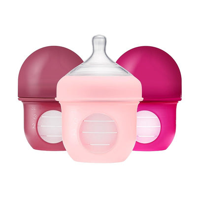 Boon NURSH Silicone Pouch Bottles 3-Pack in pink and purple, each with measurement markings and a silicone base for easy grip.