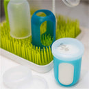 Boon NURSH Storage Caps 3-Pack displayed on a drying rack, featuring colorful silicone caps and a blue storage container labeled with a date.
