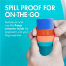 Boon YUVI Sunscreen Applicator held in hands, features a twist cap to keep sunscreen contained, with colorful sections.