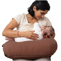 Boppy Nursing Pillow Luxe in Chestnut Muslin supports a mother as she breastfeeds her baby comfortably.