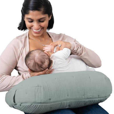 Boppy Nursing Pillow Luxe in sea green muslin is supporting a mother breastfeeding her baby.