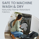 A woman in a cozy sweater places a car seat cushion into a washing machine, emphasizing its machine-washable features.