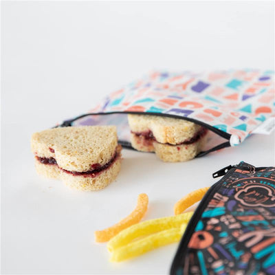Reusable sandwich and snack bags featuring a colorful geometric design, with a sandwich and snack sticks visible.