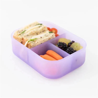 Bumkins purple bento box with three compartments, holding sandwiches, grape tomatoes, carrots, and mixed berries.
