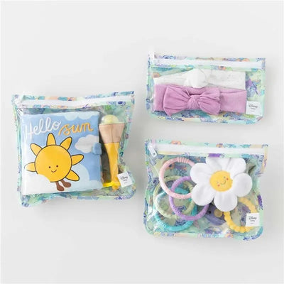 Clear travel bags featuring a sunny design, showcasing items like a plush toy, hair accessories, and colorful rings.