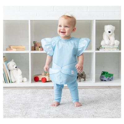 Toddler wearing a blue Bumkins Disney Princess Ruffle Apron Bib styled as Cinderella, smiling in a bright setting.