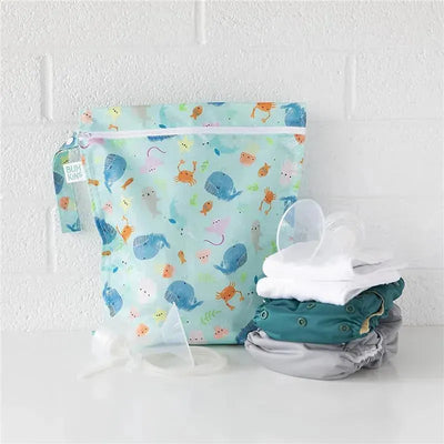 Waterproof wet bag by Bumkins with ocean life design, alongside reusable diaper covers and accessories.