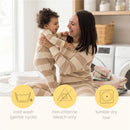 Mother joyfully holds her child, both wearing striped pajamas, with laundry and care instructions displayed below.