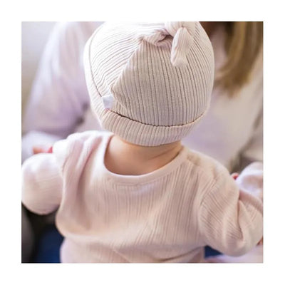 Baby wearing a soft lavender ribbed hat and matching outfit, enjoying cozy moments with an adult.