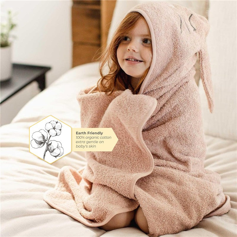 Burts Bees Organic Cotton Toddler Hooded Bunny Towel in soft pink, featuring bunny ears, worn by a smiling child.