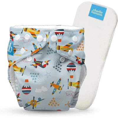 Aviator-patterned Charlie Banana reusable cloth diaper, featuring bright airplanes and balloons on a light blue background.