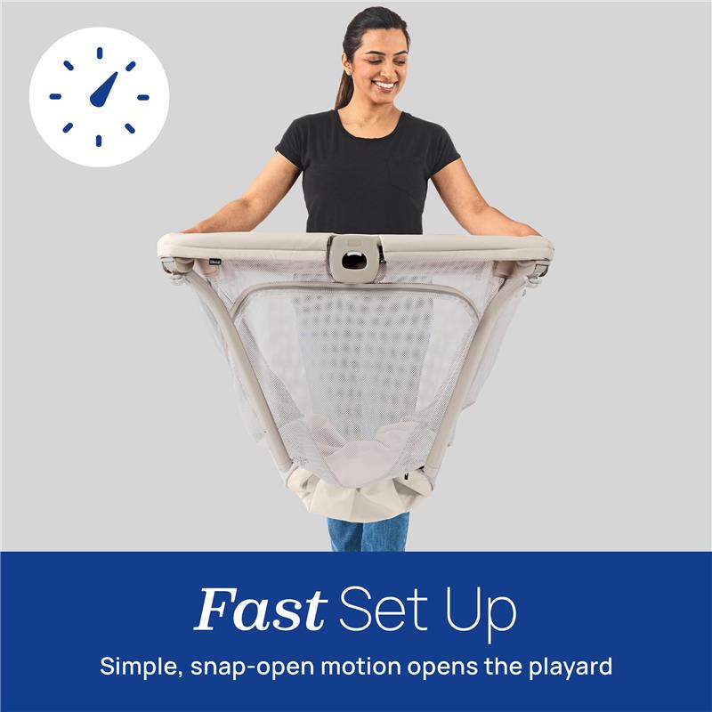 Chicco Alfa Lite portable playard being held by a smiling woman, showcasing its fast, simple snap-open setup feature.