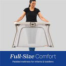 Chicco Alfa Lite Portable Playard being held by a woman, featuring a mesh design and a padded mattress for infants and toddlers.