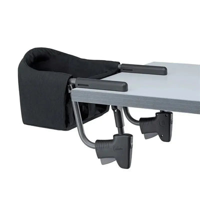 Chicco FastLock Hook-On High Chair in black, securely attached to a table with adjustable clamps.