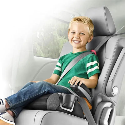 Backless booster car seat from Chicco in Shark design, with a smiling child securely buckled in, sitting in a vehicle.