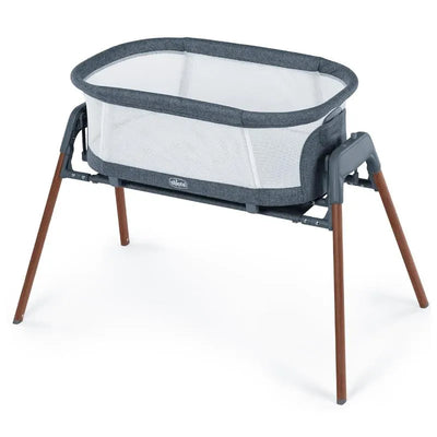 Chicco LullaGlide 3-in-1 stationary baby bassinet with a gray fabric mesh and wooden legs.