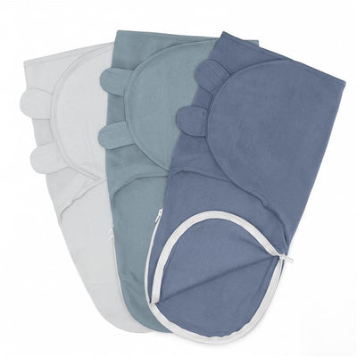 Three Comfy Cubs easy swaddles in stone, pacific blue, and nomadic blue, featuring rounded corners and zipper openings.