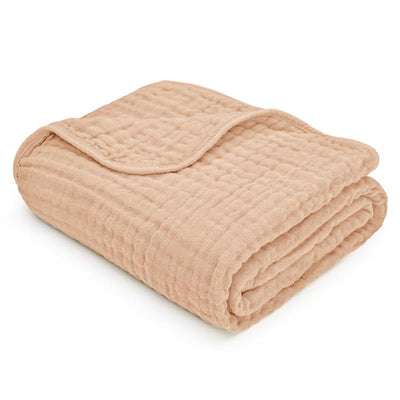 Cream-colored Comfy Cubs muslin baby blanket, featuring a soft, quilted texture, neatly folded.