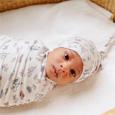 Minnie Mouse Bowquet knit blanket wrapped around a baby, featuring a floral pattern with pastel colors.