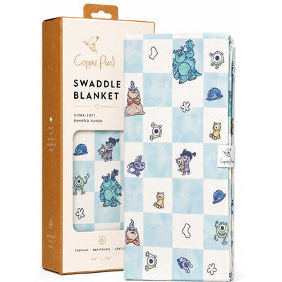 Copper Pearl Monsters Inc Medley knit blanket featuring colorful characters on a blue checkered pattern, packaged attractively.