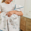 Premium Baby Knit Hooded Towel by Copper Pearl features a playful animal print, held by a smiling caregiver with a baby.