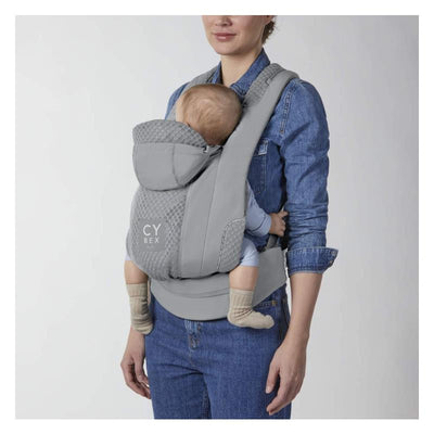 Cybex Coya Carrier in Thunder Grey worn by a woman, with a baby seated comfortably inside, featuring a hood and soft fabric.