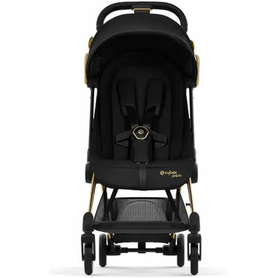 Cybex Coya Compact Stroller in black with gold accents, featuring a padded seat and safety harness, ideal for infants.