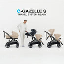 Cybex e-Gazelle S stroller with taupe frame and chocolate brown seat, featuring a man transporting the stroller system.