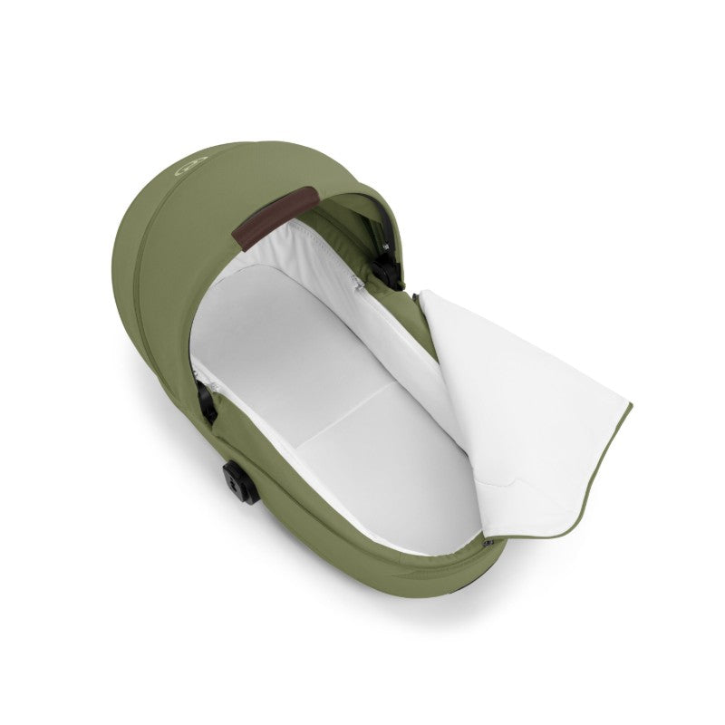 Cybex Gazelle S Cot in Moss Green, showcasing a foldable design with a white interior and brown handle detail.
