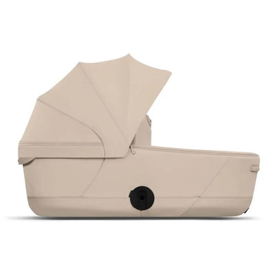 Cybex Mios/Coya Fold Lux Carry Cot in Cozy Beige with a sunshade, designed for infants.