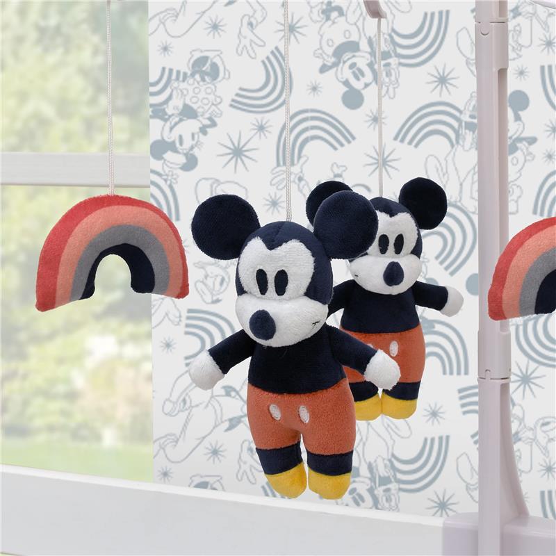 Mickey Mouse plush figures and a multi-colored rainbow hang from a mobile, designed for nursery decor.
