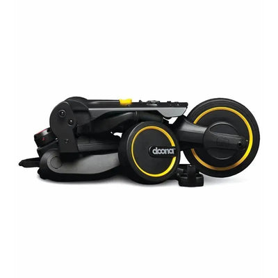 Folded Doona Liki Trike S5 in Midnight color, showcasing a compact design with black and yellow wheels and accents.